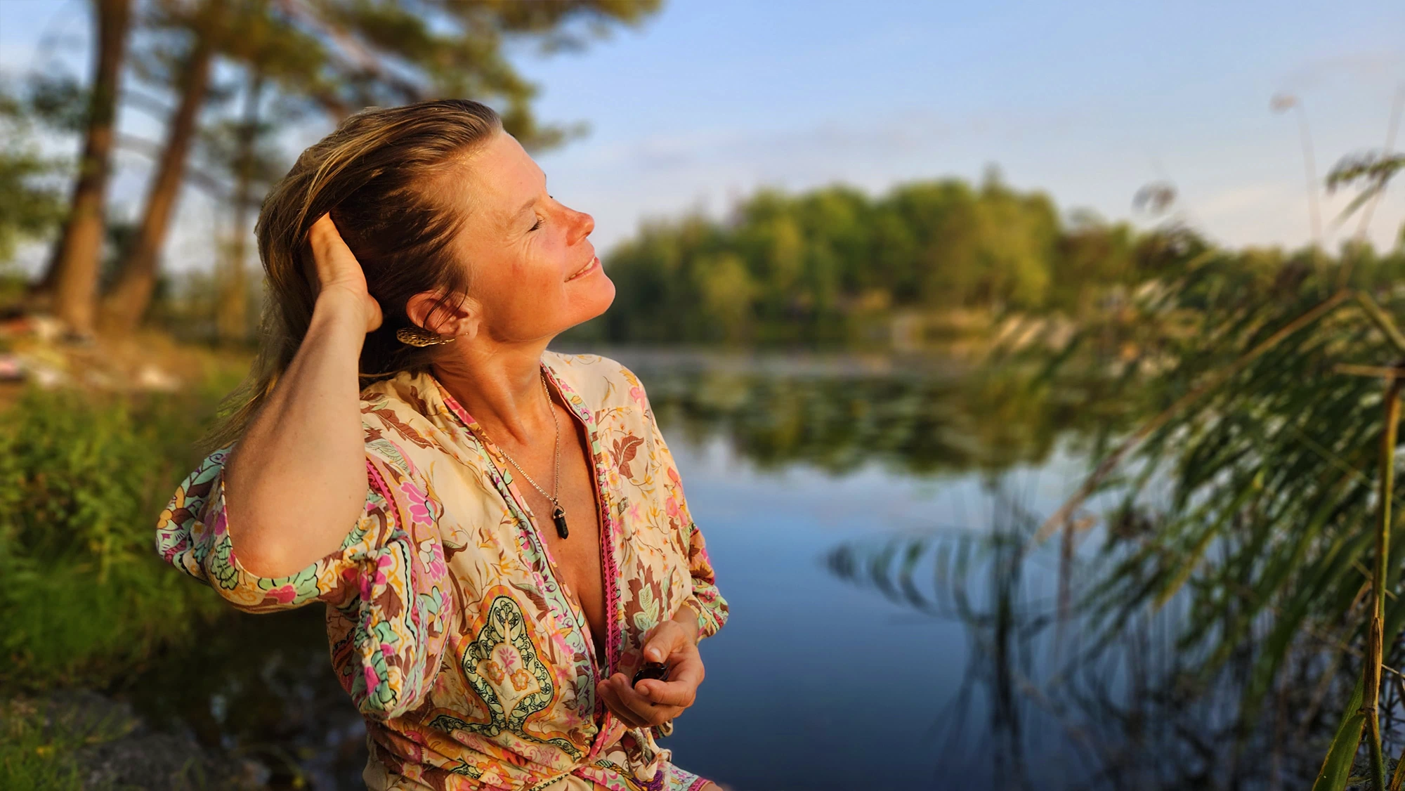 Malin Rydesjö står vid en stilla sjö
