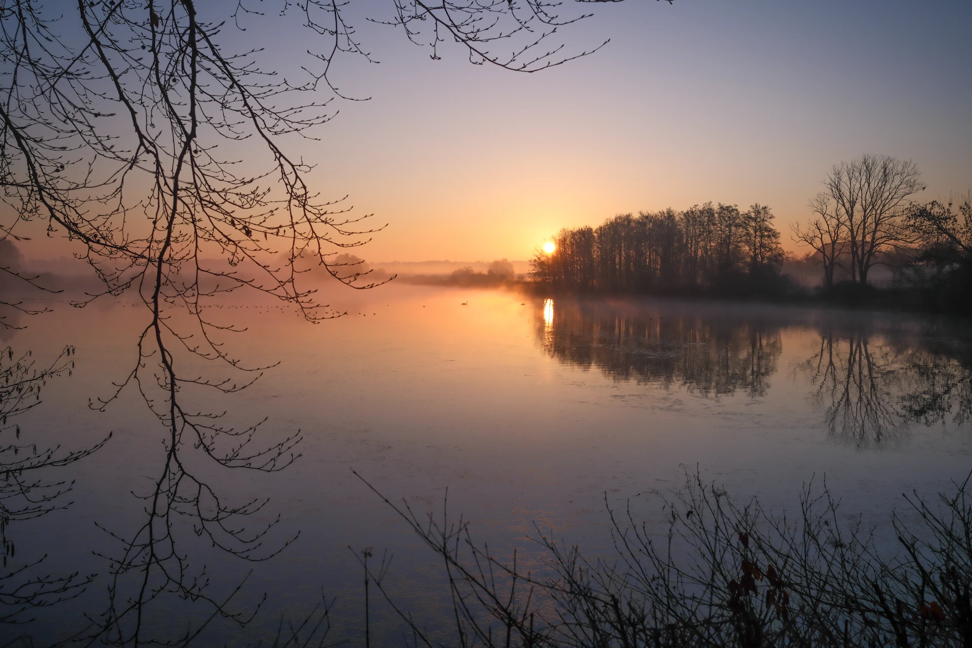 Gryningsljus över en dimmig sjö